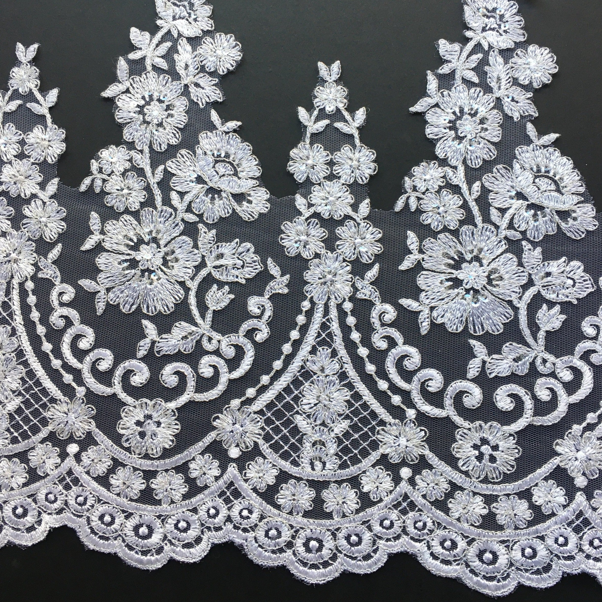 Stunning white floral lace border accented with silver thread and clear sequins.