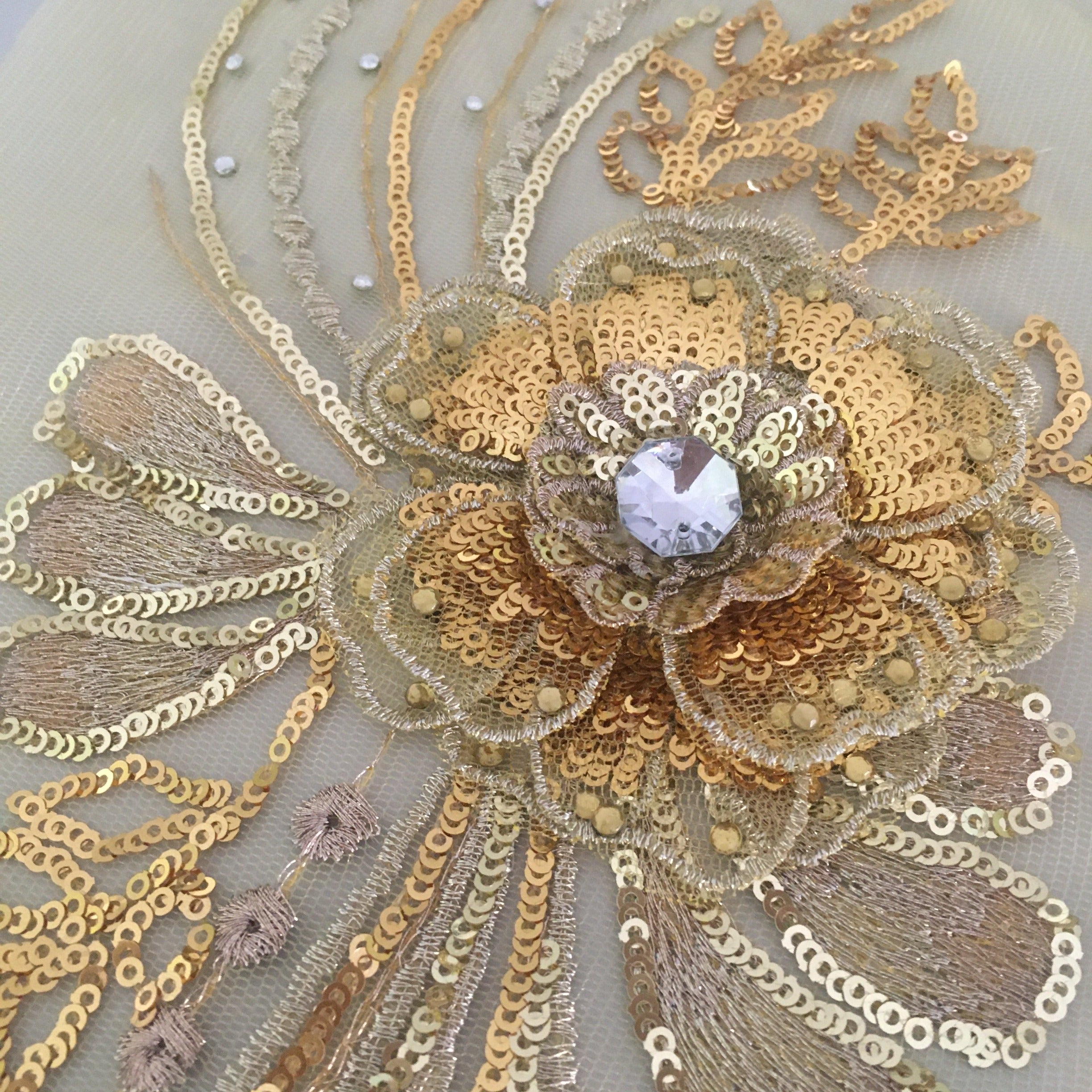 A mixture of bright and light gold metallic sequins and threads  are used in this 3d flower applique which would make a stunning addition to a dance or belly dance costume  Hotfix gems and crystals are scattered through the design.   