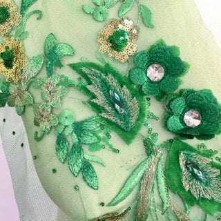 Green flower and leaf applique . Embroidered onto fine green net  