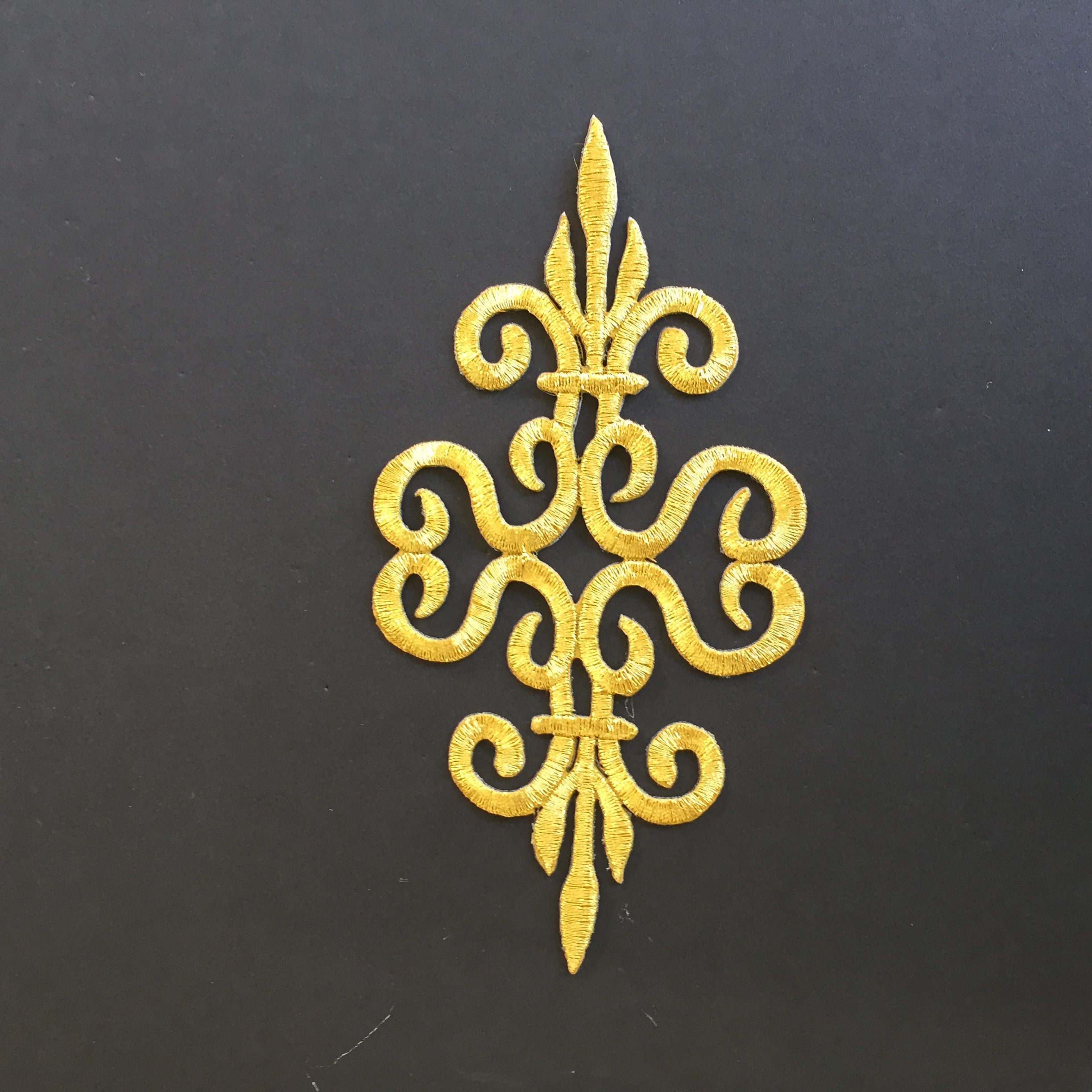 Gold cosplay iron-on patch is embroidered with gold metallic thread.