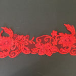 Red lace border with floral pattern and embellished with red sequins on flower centres and leaves.  Embroidered with glittery thread which sparkles under the light.