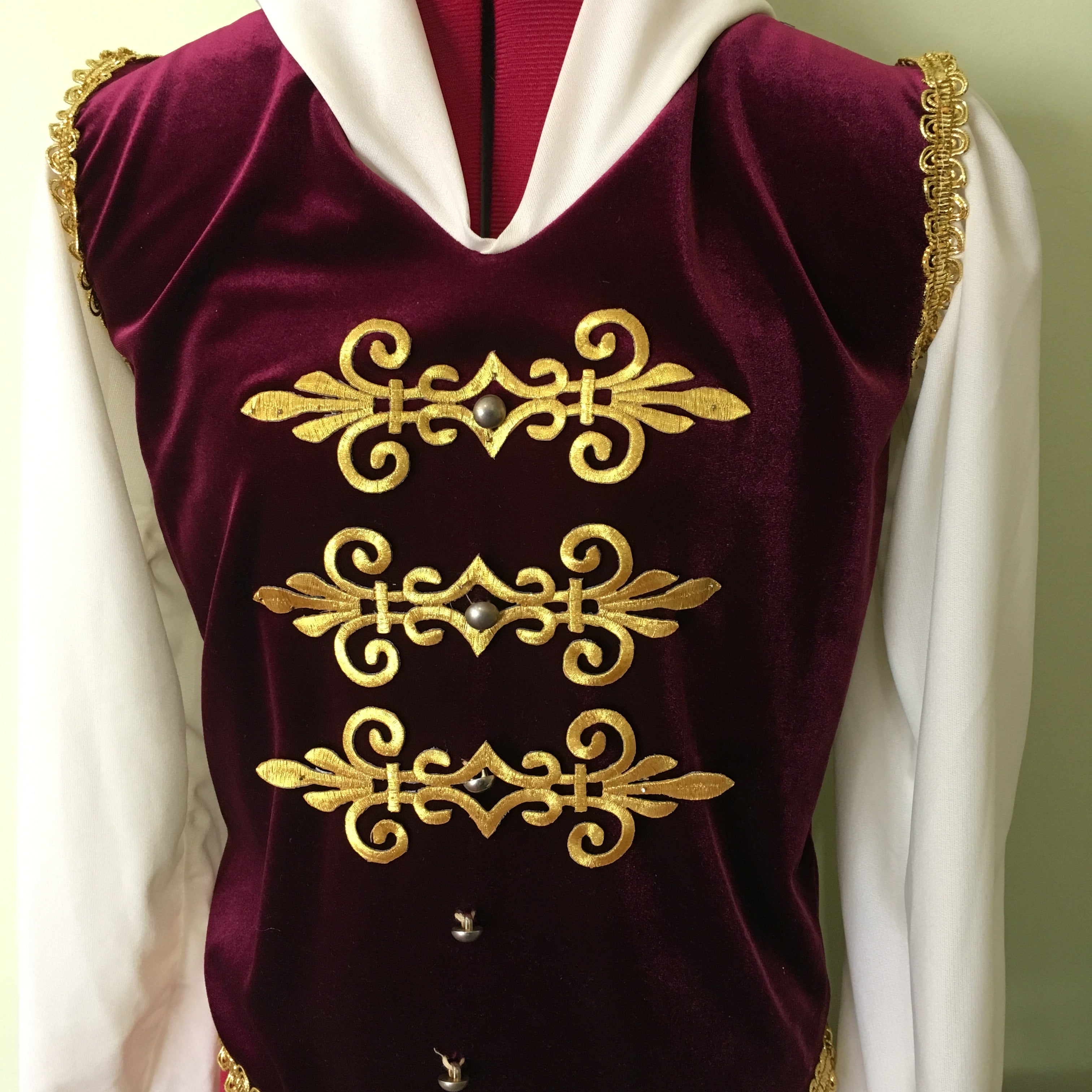The gold military style applique is a versatile decoration for boys or male ballet costume . In this photo the appliques are placed horizontally down the front to embellish the buttons.