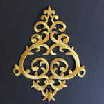 Gold metallic thread embroidered Baroque style applique in a triangular shape.  The applique is laying flat on a black background.