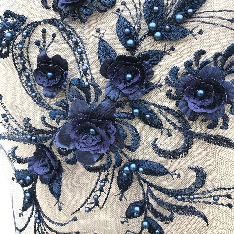 Close up of navy blue 3D floral applique piece.  The flower centres and leaves are embellished with a blue pearl.