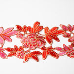 Heavily embroidered pink, red and gold floral applique scattered with hot fix AB crystals.  The petals and leaves are outlined with gold thread.