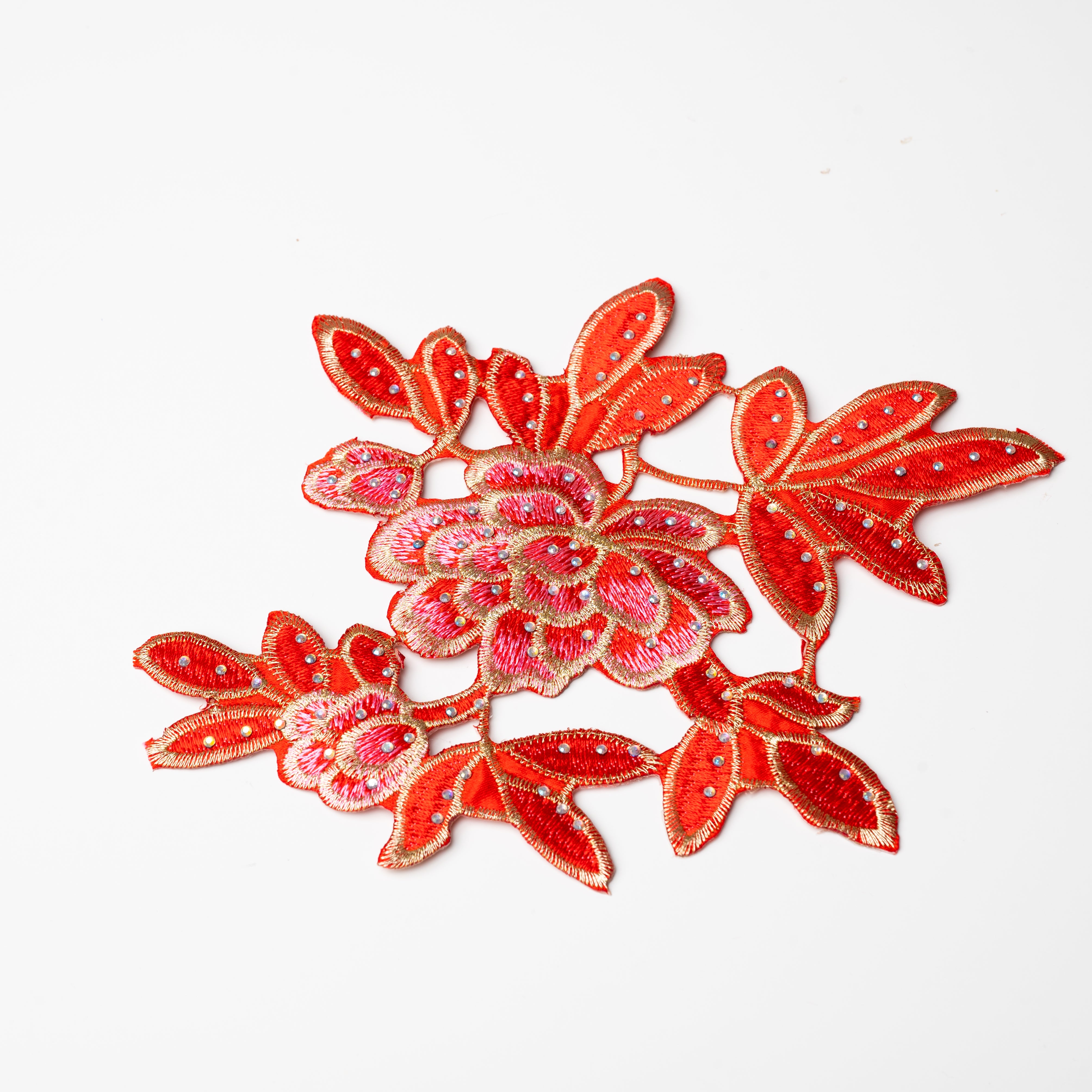 Heavily embroidered pink, red and gold floral applique scattered with hot fix AB crystals.  The petals and leaves are predominantly red and are outlined with gold thread.