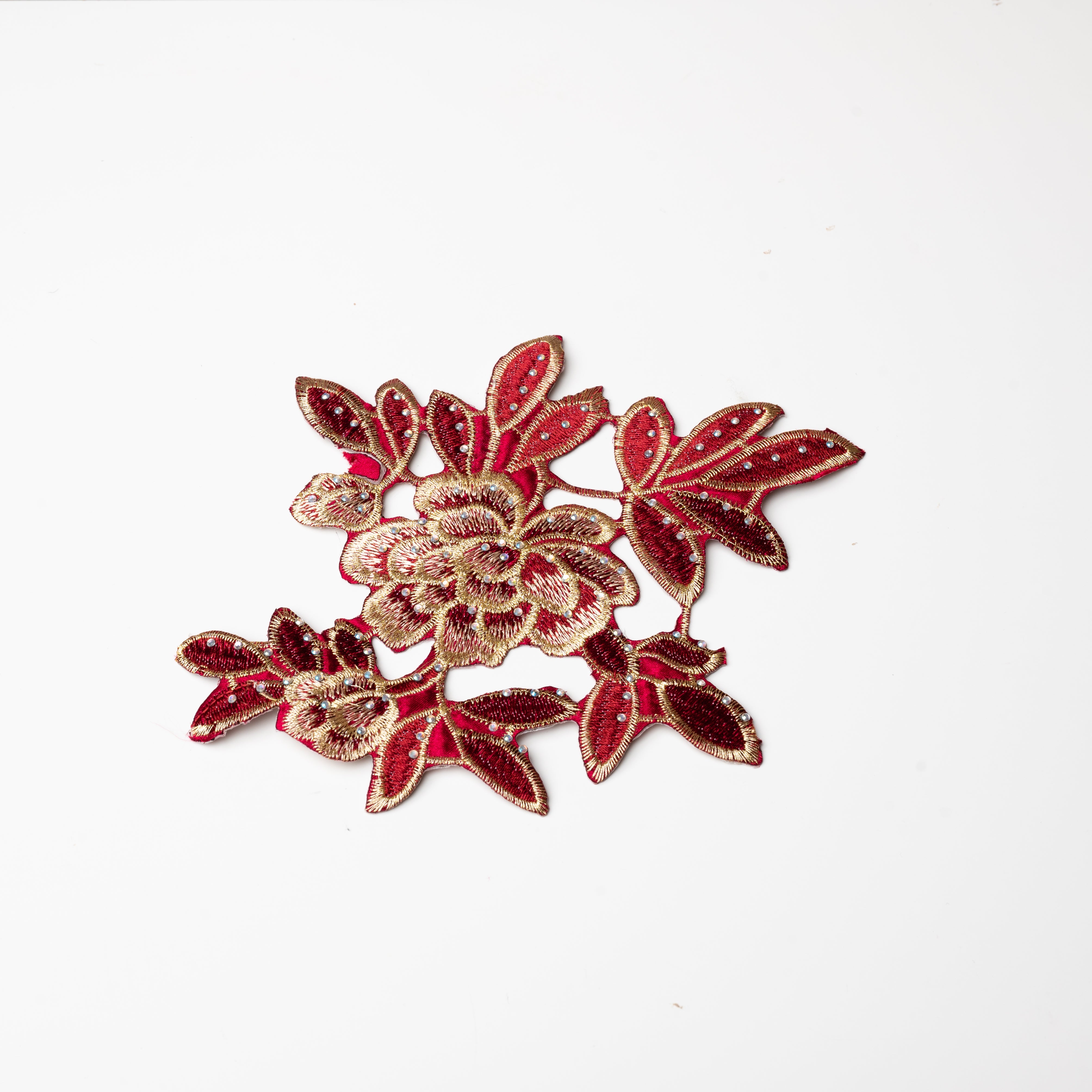Heavily embroidered burgundy and gold floral iron on applique scattered with hot fix AB crystals.  The petals and leaves are predominantly burgundy and are outlined with gold thread.