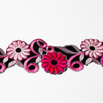 Close up view of an embroidered trim with hot pink and pale pink flowers embroidered onto black velvet.  The trim is displayed on a white background.