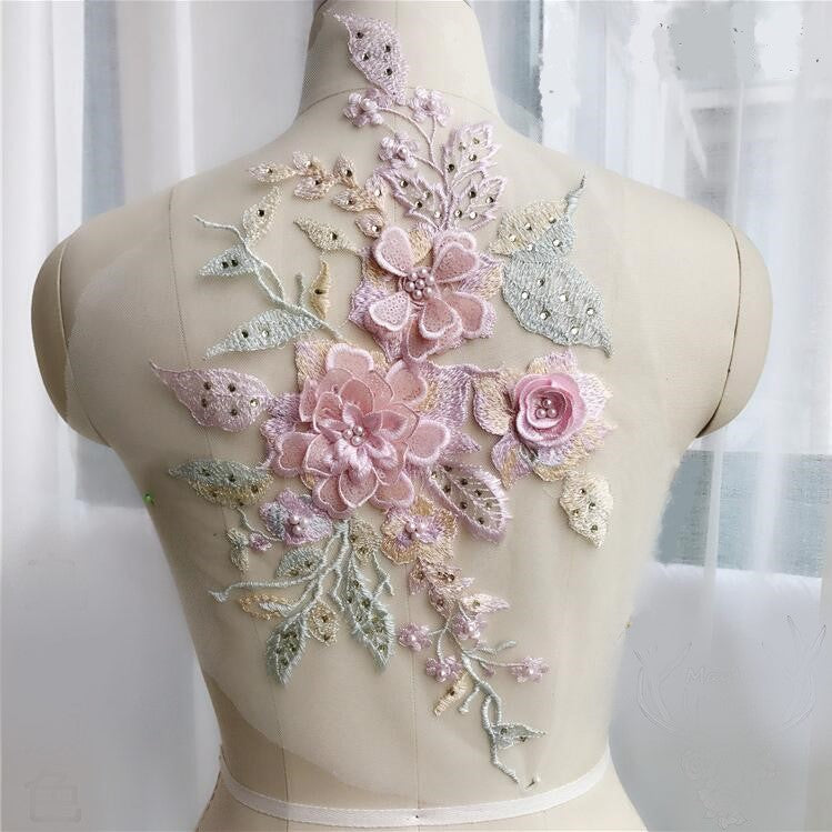 Pink and greenembroidered 3D flower and leaves  applique stuuded with  gems and sequins  displayed on a mannequin.