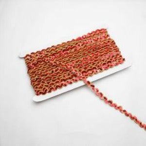 Red non-stretch sequins in a serpentine pattern edged with a metallic gold thread border.  the sequins are wrapped around a white card with a single strand lying flat across the image.