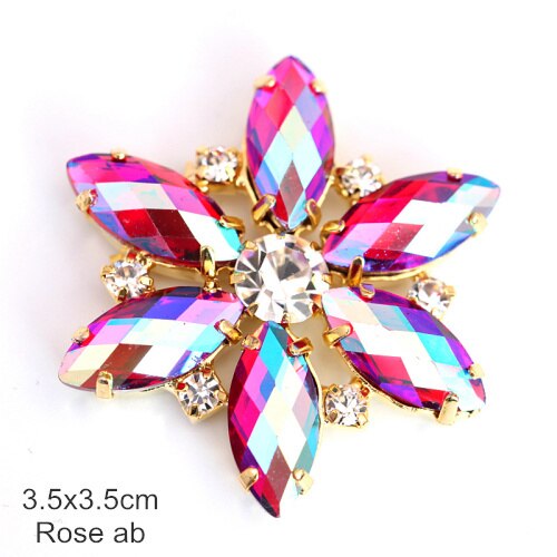 Flower shaped applique with tear drop shaped rose pink petals and a crystal rhinestone centre.  There is a crystal rhinestone in between each petal. 