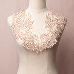 Mirrored pair of rose gold floral appliques embellished with clear sequins displayed on a mannequin.