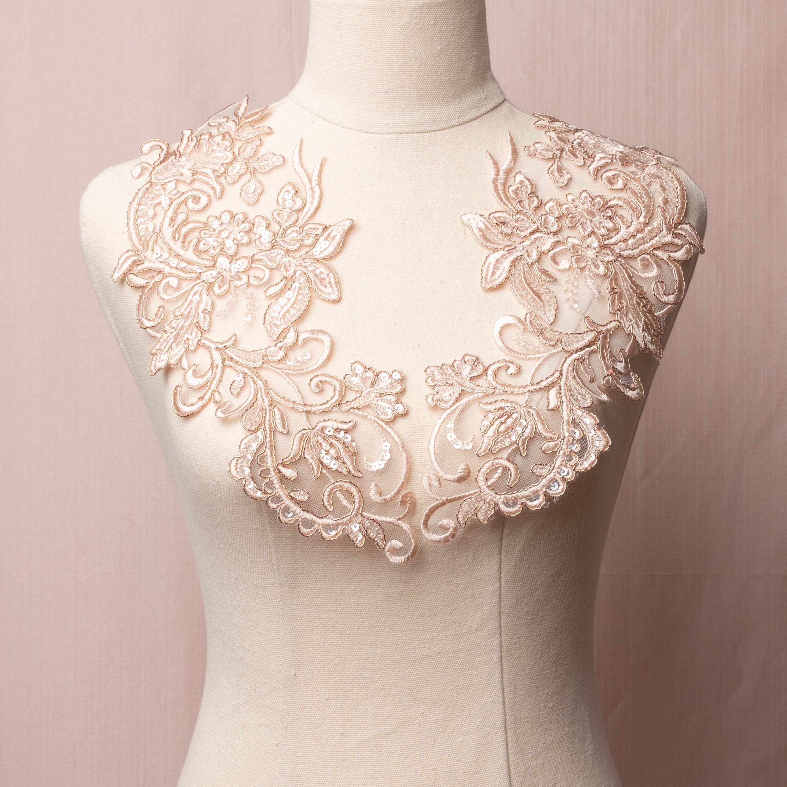 Mirrored pair of rose gold floral appliques embellished with clear sequins displayed on a mannequin.