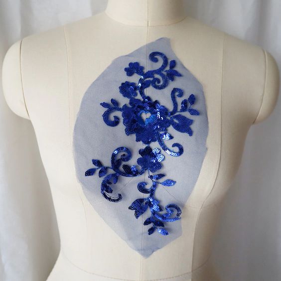 Royal Blue fully sequined floral applique embroidered onto fine blue net and displayed on a mannequin.