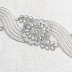 Silver crystal and pearl floral trim in a wave design embroidered with metallic silver thread and outlined with silver cord.