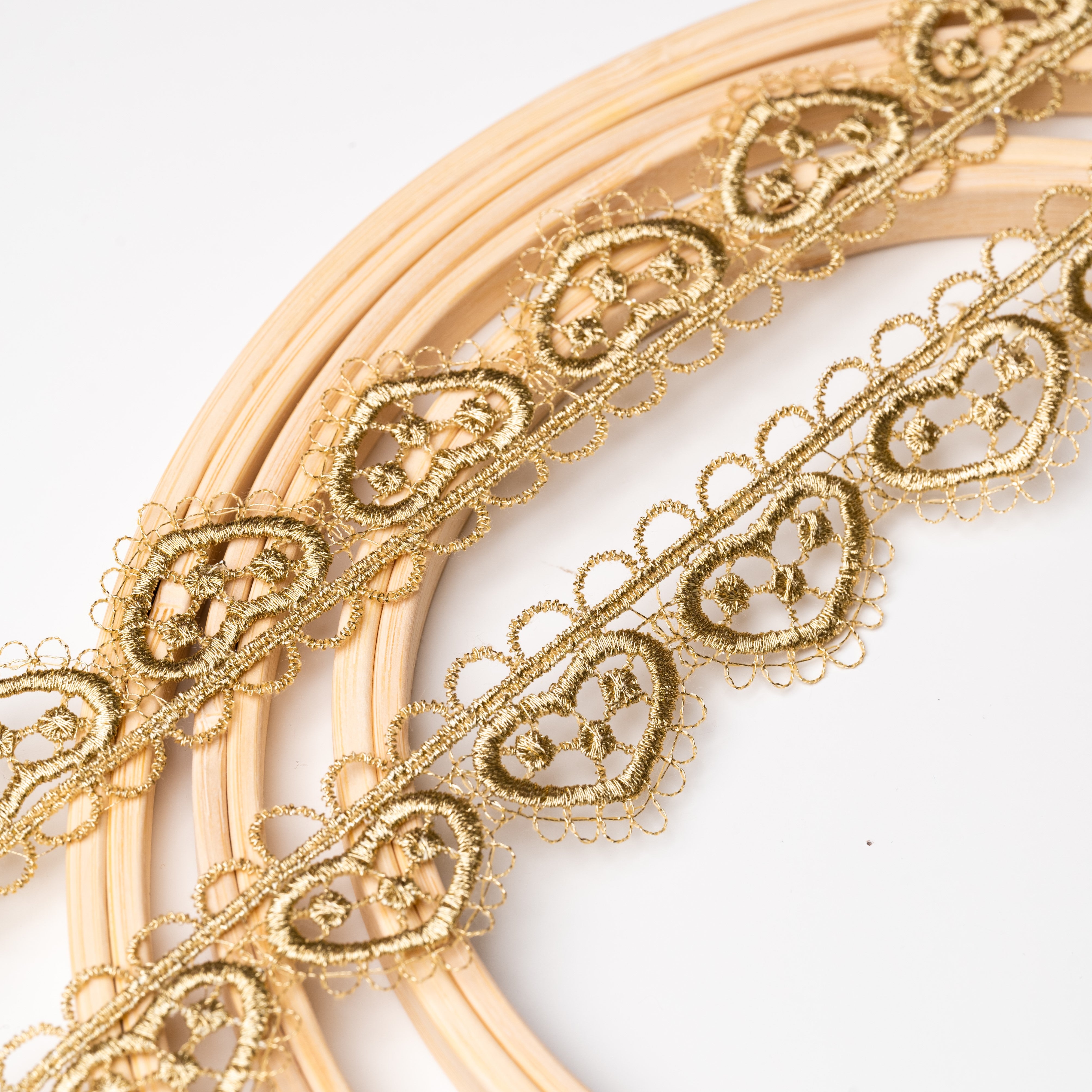 Delicate antique old gold trim with heart shaped motifs.  The trim is displayed on an embroidery ring.
