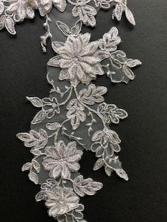 Silver cording outlines the embroidered applique and gives definition and a subtle shine to the applique. The smaller flowers have single layer sewn to the applique. The larger flowers are made from a double layer. They are heavily embroidered in a soft grey thread and are uncorded. 