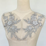 Silvery grey beaded floral applique pair displayed on a mannequin.