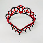Front view of red and black Spanish style tiara featuring a v shaped forehead piece embellished with red metallic beads and red and black fringing. 