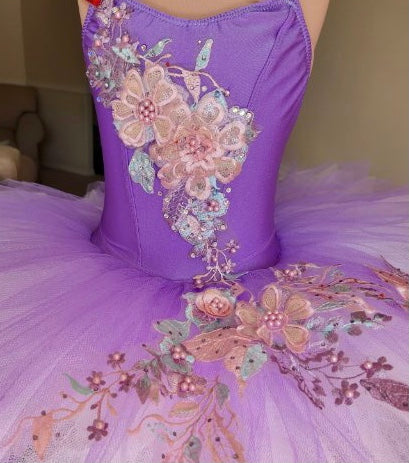 Purple ballet tutu decorated with 3D pink and lavender floral appliques on the bodice and tutu plate 