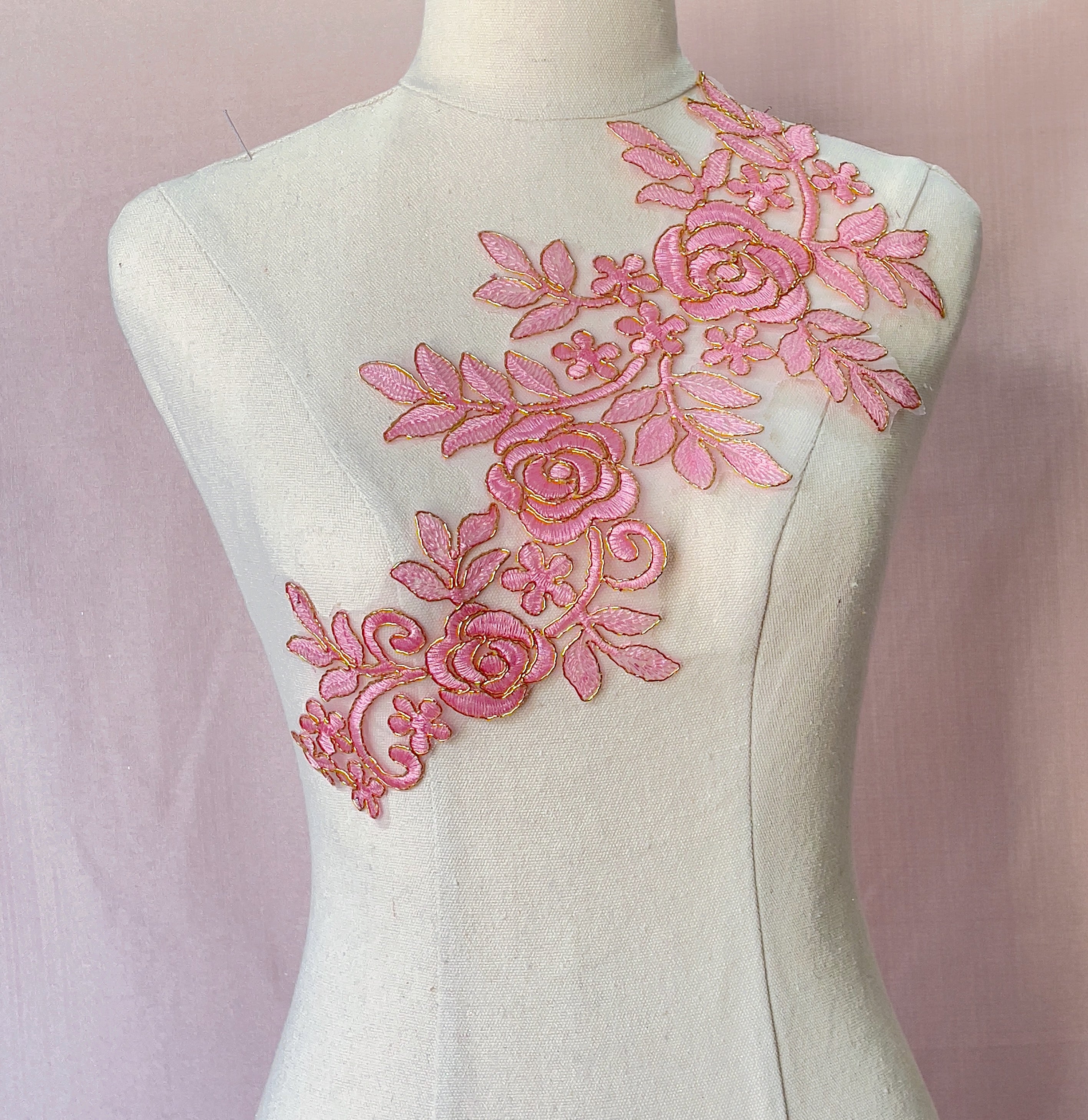 Large pink applique with a floral design and outlined with cold.  The applique is perfect for dance and stage costumes and can be embellished with crystals,  sequins and beads.  