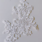 Close up of Ivory embroidered corded lace applique with a floral design