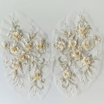Cream and ivory 3D floral applique mirrored pair embroidered onto a net backing with cream and silver threads.  The flower centres and leaves are embellished with pearls.