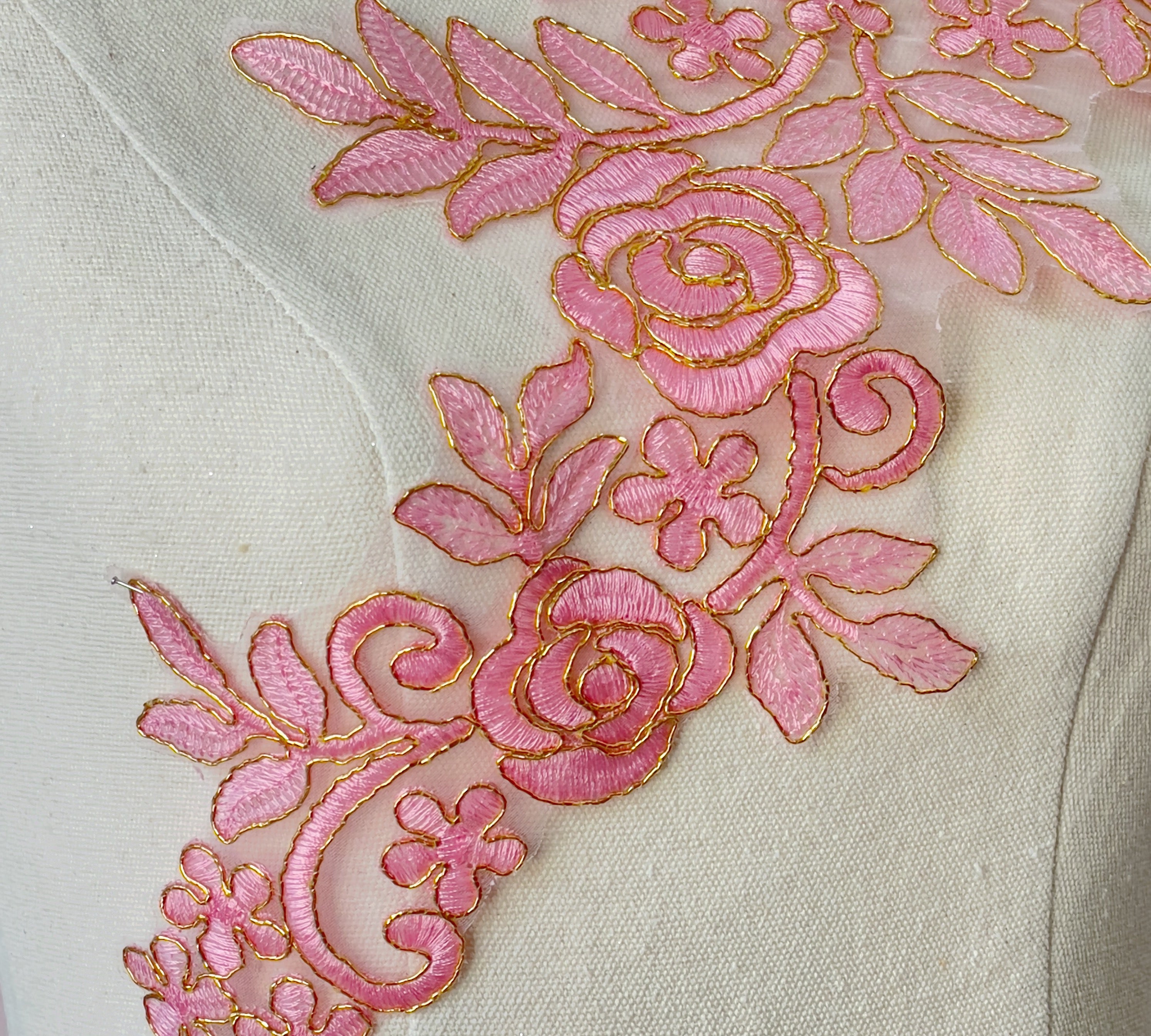 Pink embroidered floral applique with a rose pattern.  Gold cord outlines all the flower, leaf and stem shapes and the rose petals.  A bold applique which will stand out against the costume fabric. 