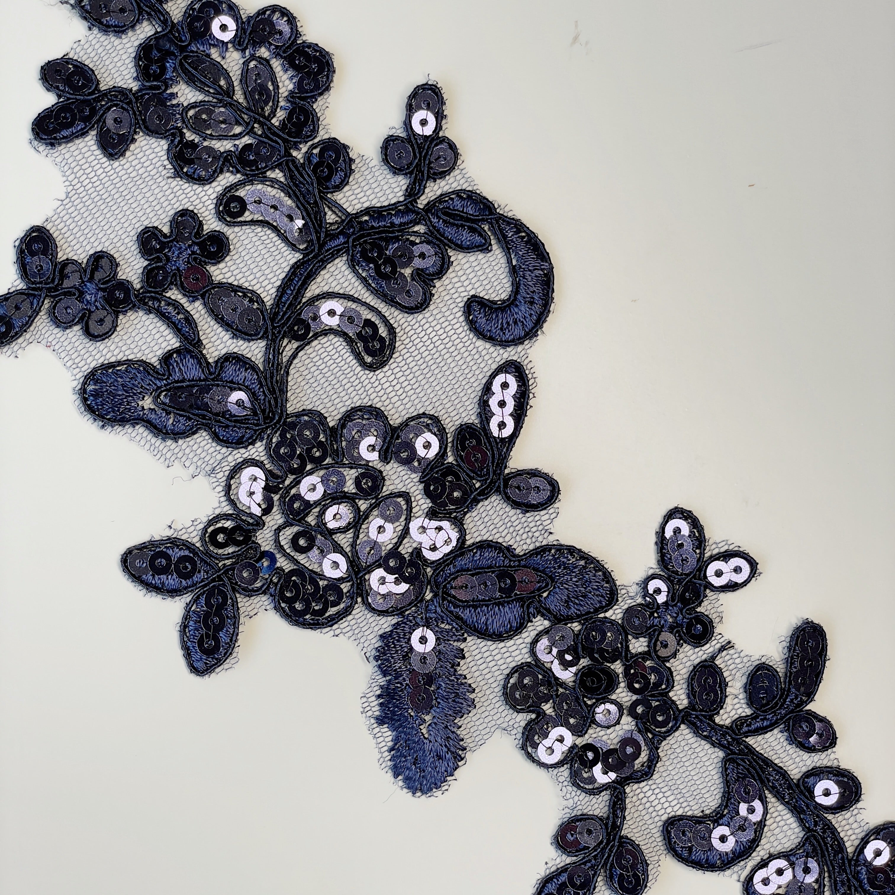 Navy blue embroidered and corded floral applique pair embellished with sequins.
