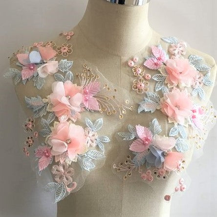 Blue and pink floral applique with 3D fabric flowers displayed on a mannequin.